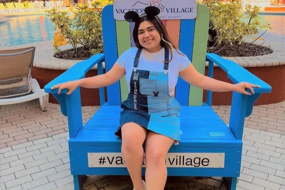 Guest posing in oversized blue Adirondack chair at the resort