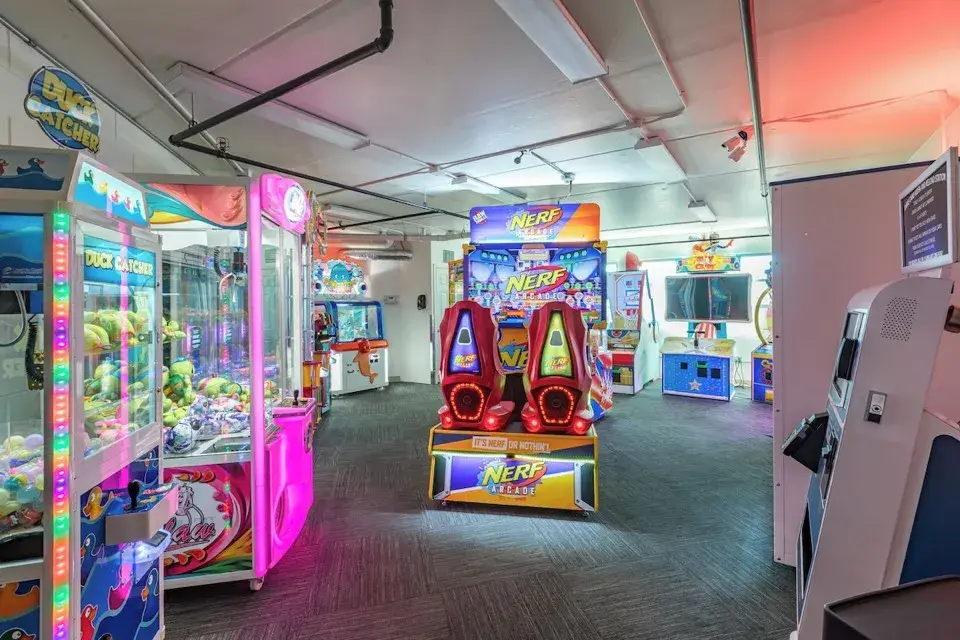 Arcade room with colorful claw machines and neon lighting