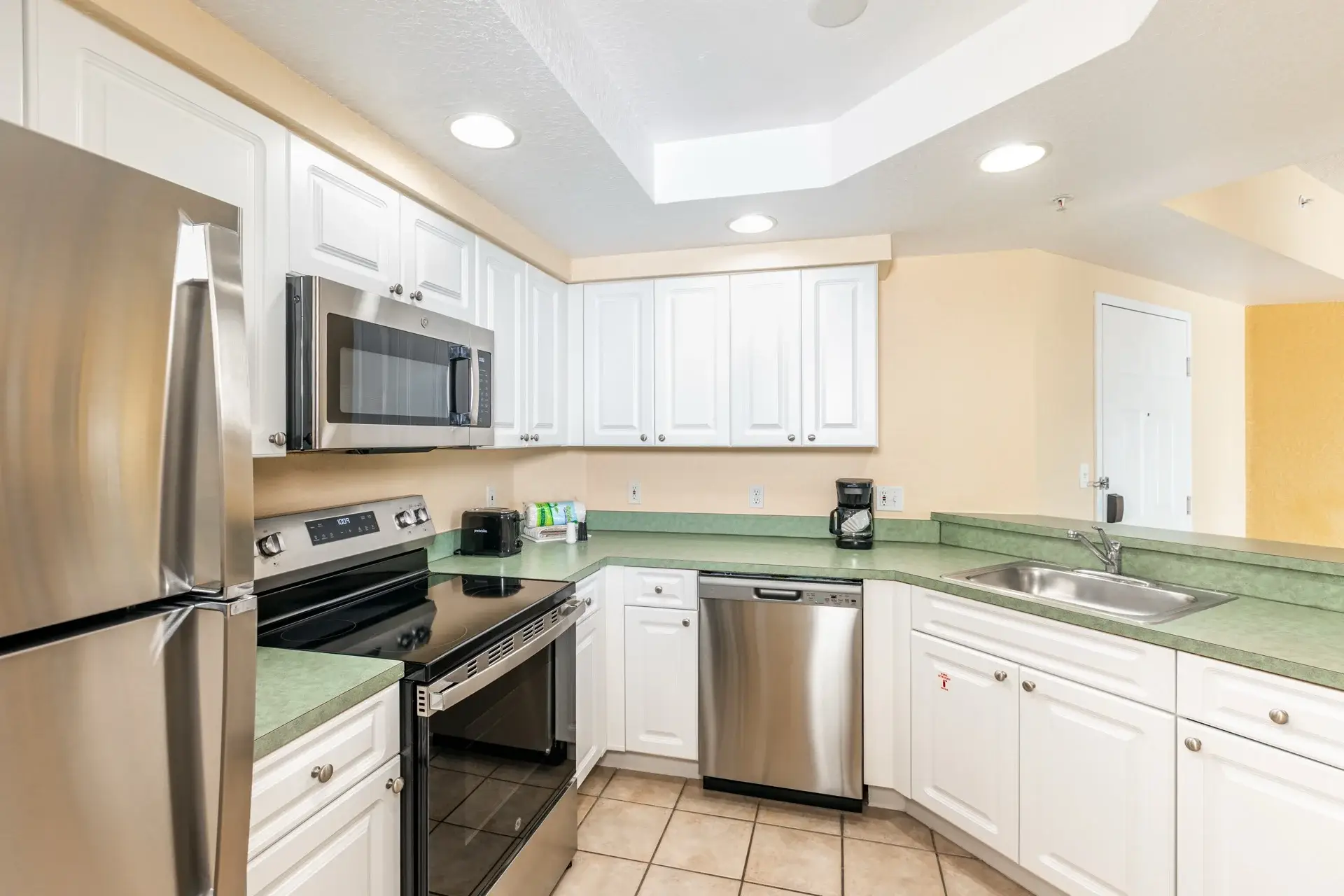 A Suite kitchen with full-size refrigerator, stove, microwave oven, and dishwasher