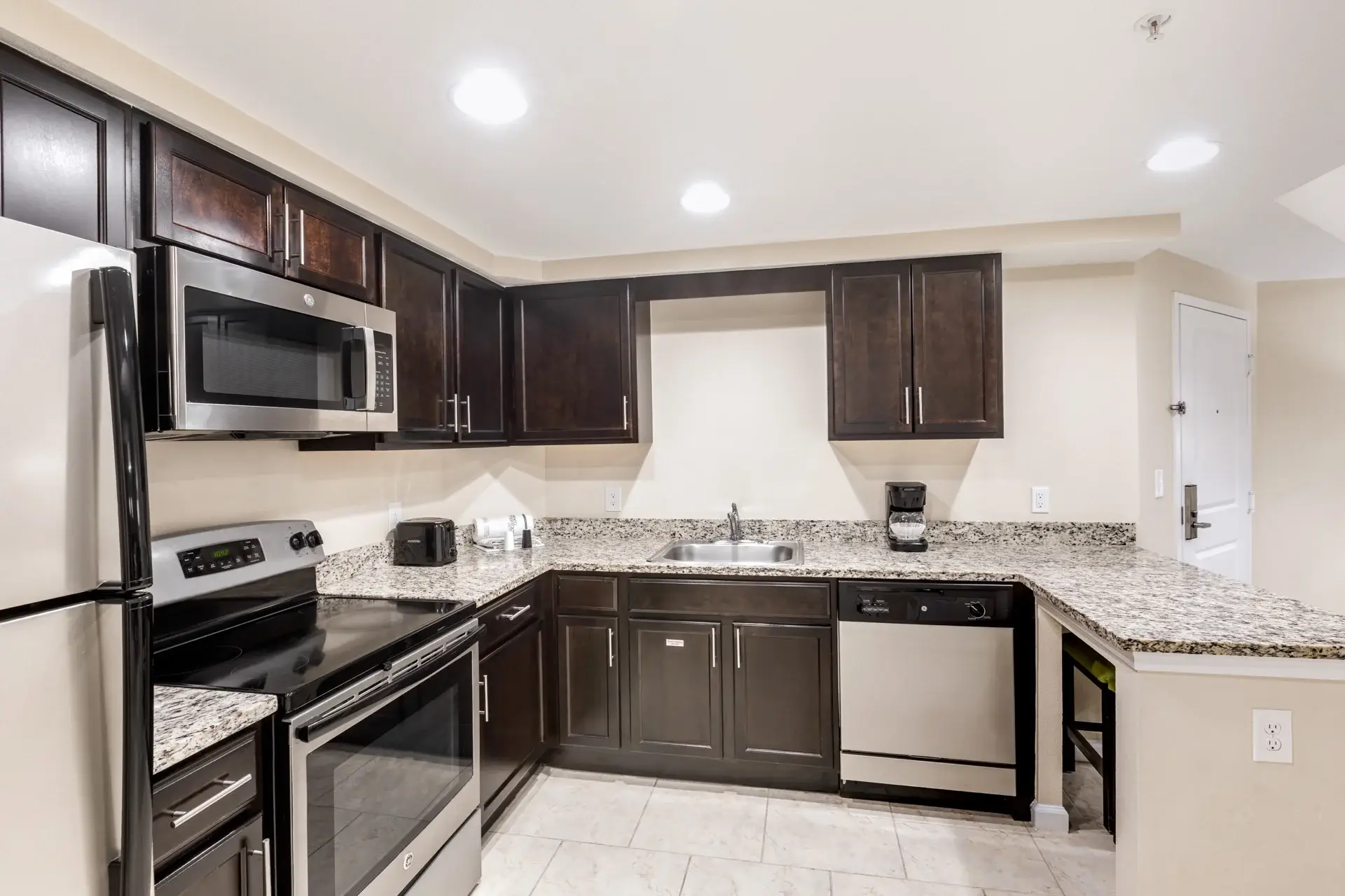 A Suite kitchen with full-size refrigerator, stove, microwave oven, and dishwasher