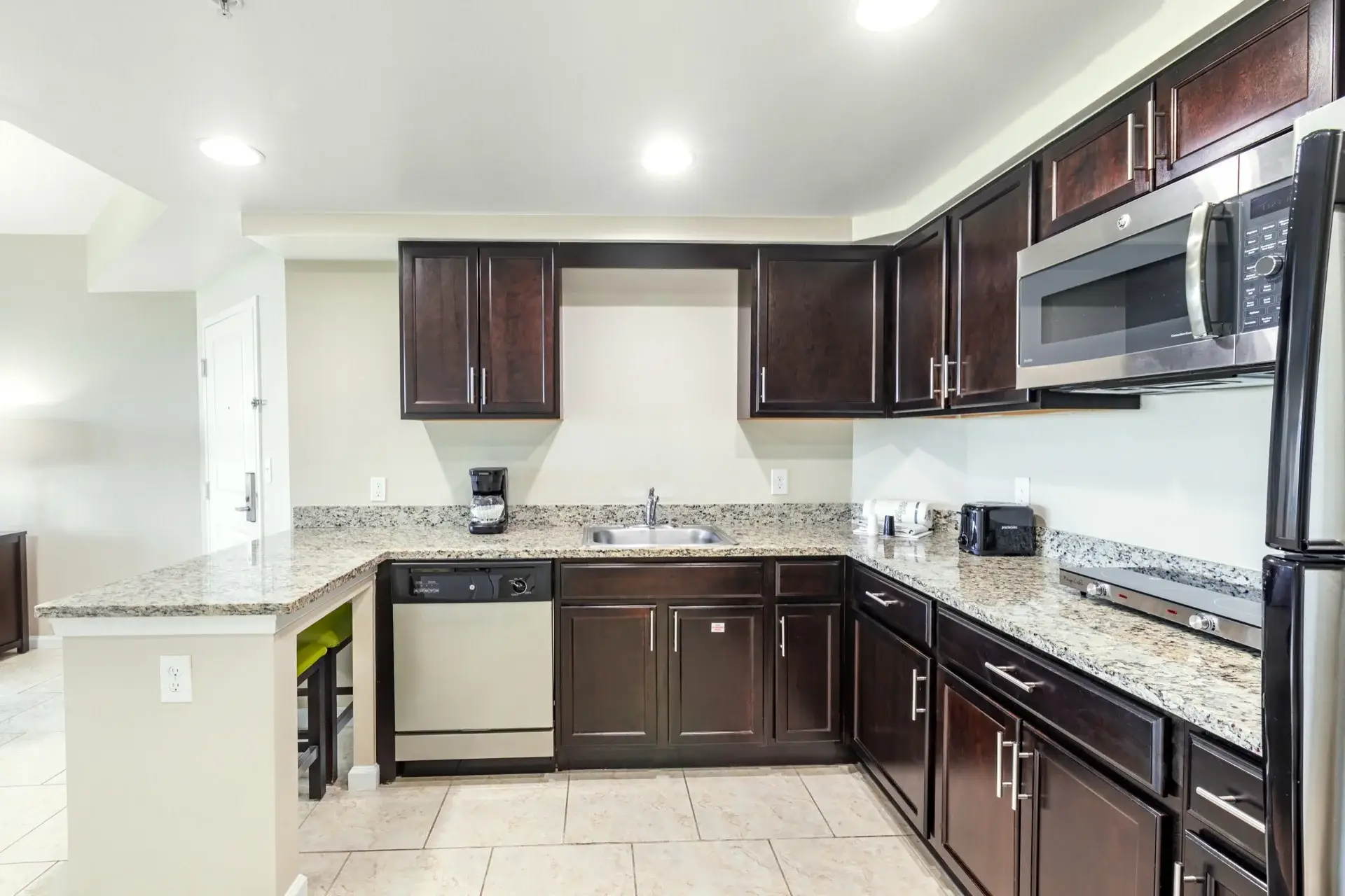 C Suite kitchenette with full-size refrigerator, microwave oven, two-burner hot plate, and dishwasher